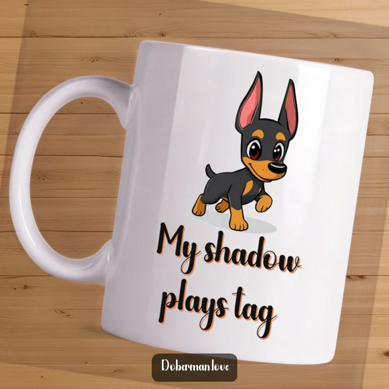 Funny Doberman mug showcasing a vigilant dog intensely focused on playfully chasing its own shadow, embodying playful paranoia.