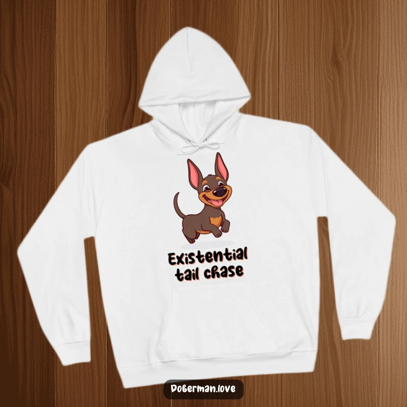 Funny Doberman hoodie depicting a joyful dog with a wide smile, enthusiastically pursuing its own wagging tail.