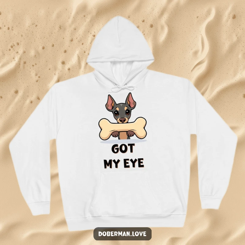 Funny Kawaii Doberman hoodie depicting a cute dog peeking from behind a giant bone, offering warmth and humorous charm.