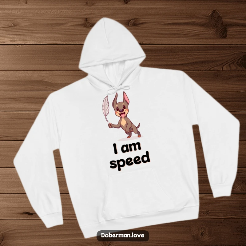 Funny Kawaii Doberman hoodie showing an excited dog leaping energetically towards a small feather, cozy and full of action.