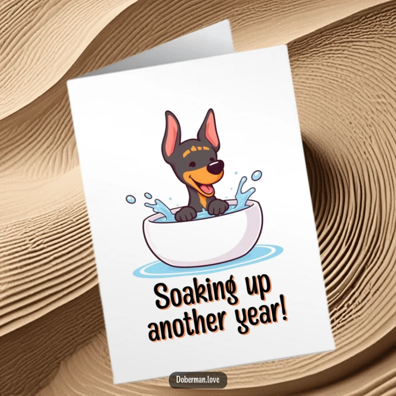 Funny Free Printable Birthday Card: Kawaii Doberman joyfully splashing water from a bowl with a huge grin