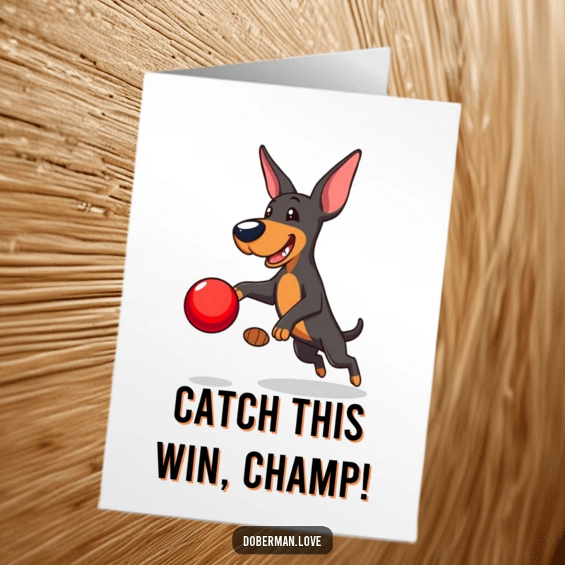 Funny Free Printable Congrats Card: Playful Doberman leaping to catch a shiny red ball, symbolizing a winning moment.