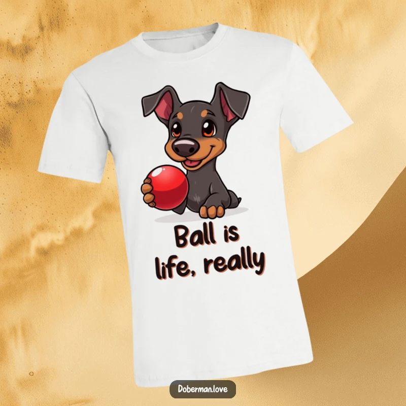 Funny Doberman t-shirt featuring a delighted dog with loving eyes, offering a shiny red ball, perfect for fetch lovers.