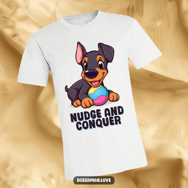 Funny Doberman T-Shirt: Cheerful dog nudging a perfectly round, colorful toy, a happy and funny depiction.