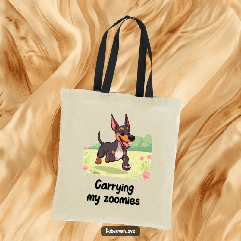 Funny tote bag with a giggling Doberman and a wagging tail, running through a field, perfect for carrying dog essentials.