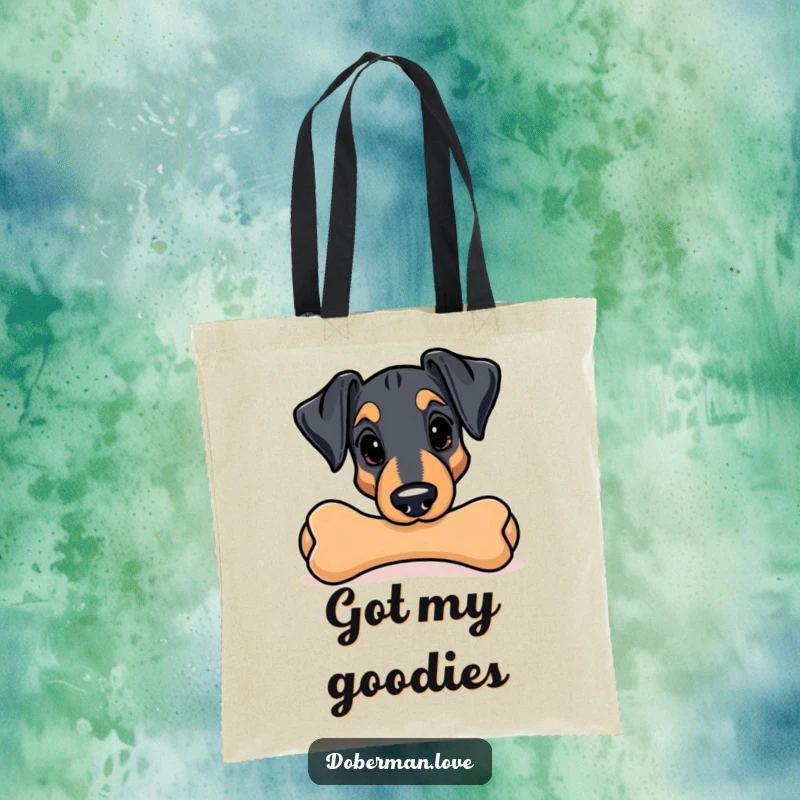 Funny Kawaii Doberman tote bag; a playful dog peeks out from behind a giant chew toy, ready for adventure.